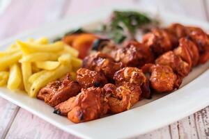 SHISH TAWOOK tikka kabab with fries and salad served in dish isolated wooden table top view of tandoori grill bbq food photo