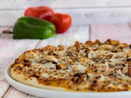 Polo Chicken Pizza topping with capsicum, mushroom, tomato and olives served in dish isolated on table side view of arabic fastfood photo