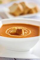 TOMATO SOUP with bread and lemon slice served in bowl isolated on table closeup top view of hot soup photo