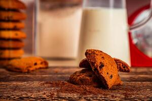 Tasty Chocolate cookie with jug of milk served on wooden board side view of healthy breakfast on table photo