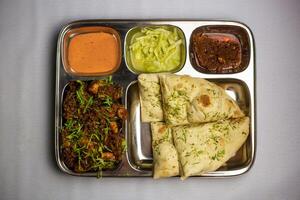 Chicken Masala chaap with garlic nan, chuntney, sauce and chilli dip served in thali platter isolated on background top view of bangladeshi food set menu photo