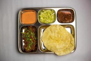 Beef Chaap with Lucchi with chuntney, sauce and chilli dip served in thali platter isolated on background top view of bangladeshi food set menu photo