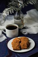 Crunchy cookies biscuits served in plate with black coffee isolated on table side view of american cafe baked food photo