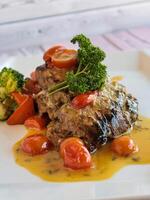 GRILLED HAMOUR Fish with gravy, broccoli and tomato served in dish isolated on table closeup top view of grilled seafood photo