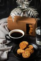 crujiente galletas galletas servido en plato con Galleta caja, negro café y vaso de agua aislado en mesa lado ver de americano café horneado comida foto