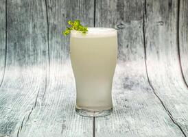 Fresh lime soda juice with mint served in glass isolated on wooden table top view of indian drink photo