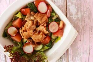 fattoush ensalada con galletas saladas, tomate, pepino, y lechuga hoja servido en plato aislado en mesa de cerca parte superior ver de sano orgánico comida foto