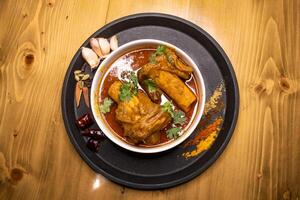 Beef Nali Nihari or Nolar Jhol served in dish isolated on wooden background top view indian spices, bangladeshi and pakistani food photo