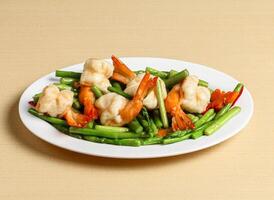 fried prawns with asparagus served in dish isolated on background top view singapore food photo