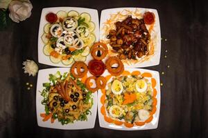 Assorted salads variety with chicken vegetable cashew nut salad, classic Greece salad, russian salad, grilled chicken, munchies, fried onion rings served isolated closeup top view of healthy food photo