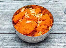 Rava kesari halwa sweet with nuts served in dish isolated on wooden table top view of indian dessert food photo