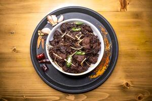 Kala Bhuna Gosht karahi served in dish isolated on wooden background top view indian spices, bangladeshi and pakistani food photo