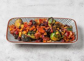 brussel sprouts salad with tomato and corn served in dish isolated on grey background top view of singapore food photo