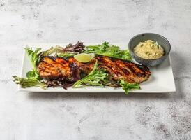 chao ta grilled belly good with plain rice, lemon and green leaves served in dish isolated on grey background top view of singapore food photo