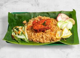 Fried Fish Biryani with salad served in dish isolated on banana leaf top view of singapore food photo