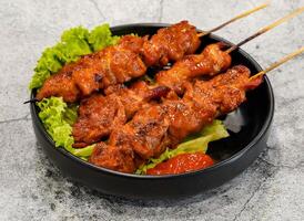 grilled meat on skewers or thit nuong xien que witth lettuce leaf served in dish isolated on grey background top view of singapore seafood photo