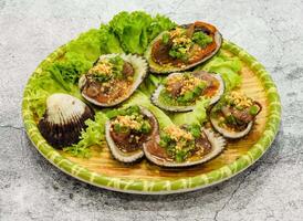 grilled scallops with green onion or so long nuong mo hanh with lettuce leaf served in dish isolated on grey background top view of singapore seafood photo