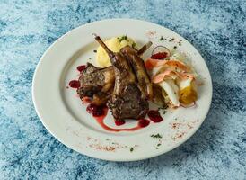 grilled lamb chops with mashed potato and egg served in plate isolated on background top view of italian food photo