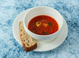 tomato soup with bread served in plate isolated on background top view of italian food photo