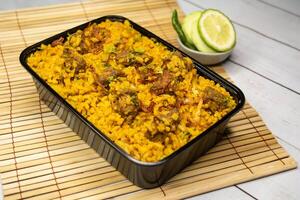 beef khichuri biryani rice pulao with cucumber and lemon slice served in dish isolated on wooden table side view of bangladeshi and indian spicy food photo