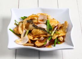 ginger onion fish fillet served in dish isolated on table top view of singapore food photo