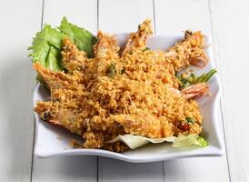 Deep fried cereal prawn served in dish isolated on table top view of singapore food photo