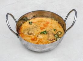 Curry pakora topping with green chilli served in karahi isolated on grey background side view of pakistani and indian spices food photo