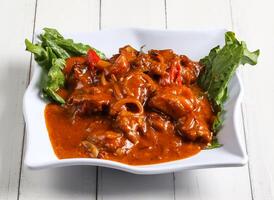 Spicy curry chicken served in dish isolated on table top view of singapore food photo