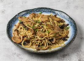 wild mushroom pasta served in dish isolated on grey background top view of singapore food photo
