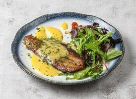 Fried fish with dip cheese sauce and salad leaves served in dish isolated on grey background top view of singapore food photo