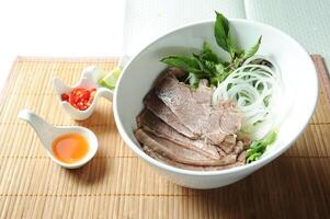 Beef Pork Brisket Soup Noodles with sauce served in bowl isolated on table top view of Soup powder photo