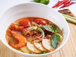 Hor Fun Soup with Fresh Tomato and Beef Brisket served in bowl isolated on table top view of Soup powder photo