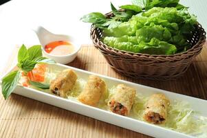 Vietnamese Style Fried Spring Rolls with chilli sauce served in dish isolated of table top view fast food snacks photo