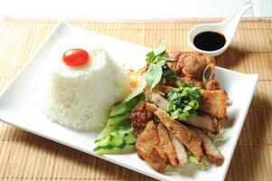 Lemongrass Pork Chop Rice with sauce served in dish isolated on table top view of meal photo