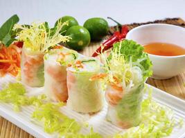 Shrimp Rice Paper Rolls with sauce and lemon served in dish isolated on table top view photo