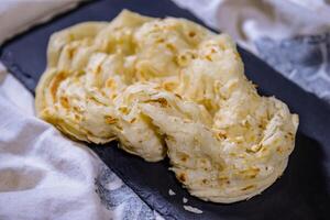 kerala parotta o en capas paratha frito en petróleo servido en plato aislado en comida mesa parte superior ver de medio este especias foto