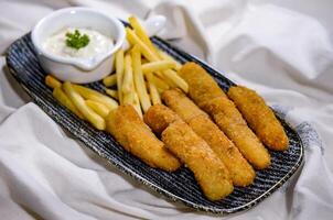 Fried Hamour finger fish with chips and dip served in dish isolated on food table top view of middle east spices photo