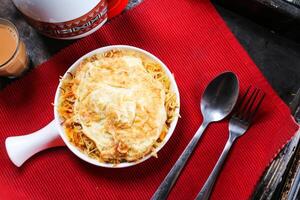 Balalet or noodles with egg omelet served in dish isolated on red mat top view on table arabic food photo