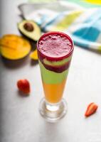 Four Layers shake with Avocado, mango with Pomegranate served in glass isolated on table top view of arabic food photo