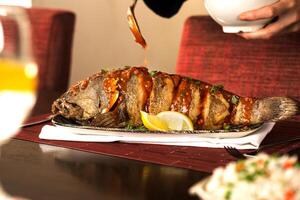 Baby hamour grilled with chilli sauce and lemon served in dish isolated on food table side view of seafood photo