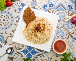 Madfoon Chicken biryani rice served in dish isolated on table top view of arabic food photo
