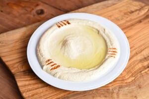 Hummus with chickpea served in dish isolated on wooden table top view middle eastern appetizers food photo