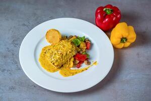 Seabass Fillet with roasted Vegetable and saffron lemon butter sauce served in dish isolated on grey background top view of bahrain food photo