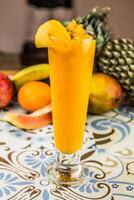 Fresh Mango Juice served in glass isolated on table top view of arabic drink photo