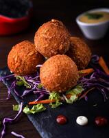 Cheese Balls with dip, onion, carrot and lettuce leaf served in dish isolated on wooden table side view of arabic food photo