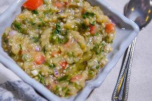 baba ghanouj con machacado berenjena, tomate y cebolla servido en plato aislado en comida mesa parte superior ver de medio este especias foto