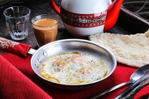 frito huevo con pan, café y tetera servido en plato aislado en rojo estera parte superior ver en mesa Arábica comida foto