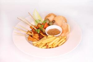 CHICKEN SATAY with dipping sauce and french fries served in dish isolated on background side view of arab food photo