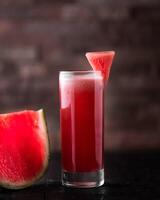 Fresh Watermelon Juice served in glass isolated on wooden table side view of arabic healthy fruit juice photo