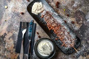 Nutella gofre palo con chocolate, azotado crema, cuchillo y tenedor servido en plato aislado en oscuro antecedentes parte superior ver café postre comida foto